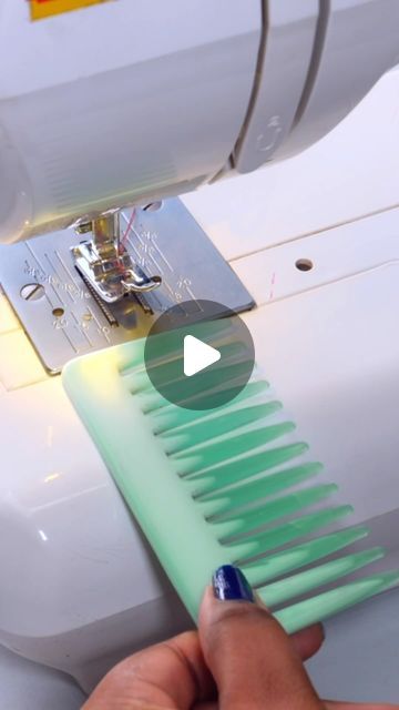 someone is using a sewing machine to sew something green and blue with the help of a needle