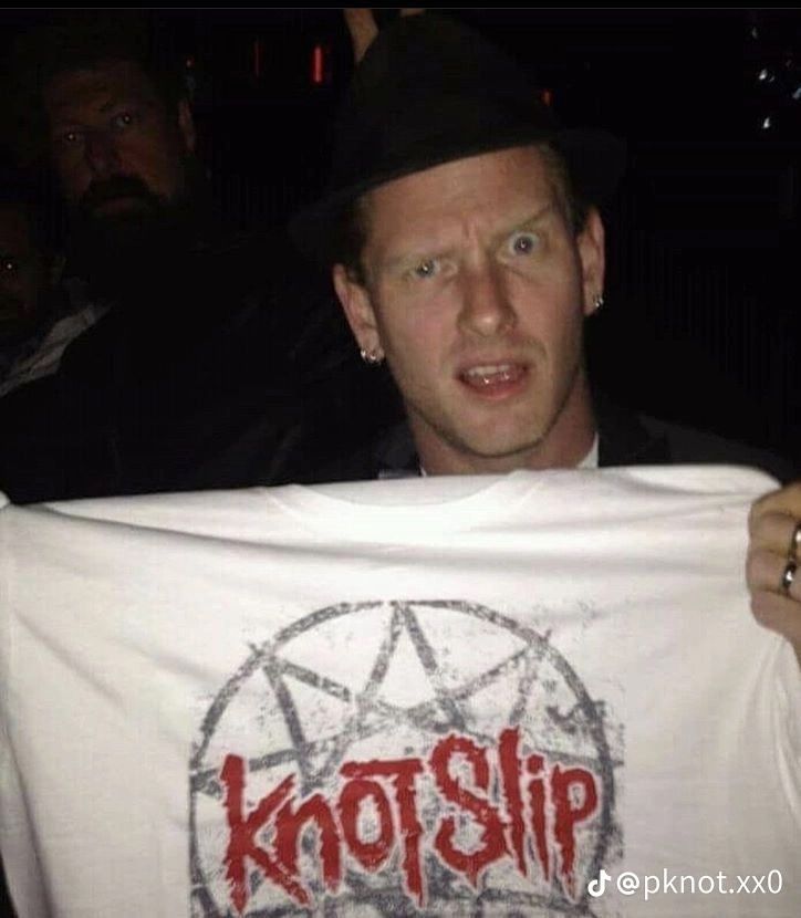 a man holding up a t - shirt with the word kotship on it