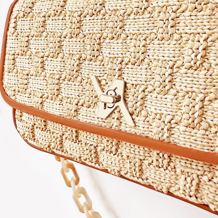 Expertly crafted from supple raffia, its design blends a structured frame and the YLIANA YEPEZ wow effect. Wear it as a hobo with its round top handle or as a cross-body bag using its chain strap. Italian Raphia Gold hardware Custom YY turn lock Resin chain body strap, 13'' (33 cm) Drop Top handle 5.5" (14 cm) Drop Internal zipped pocket Internal YY logo plaque Fabric lining Height: 5'' (12,7cm) Width: 7.5'' (19cm) Depth: 2.15'' (5,4cm) 100% Made in Italy. Cleaning and Care Our products are made Chic Jute Straw Bag With Round Handle, Woven Jute Shoulder Bag With Top Handle, Jute Woven Top Handle Shoulder Bag, Chic Woven Natural Fiber Shoulder Bag, Top Handle Woven Jute Shoulder Bag, Chic Woven Leather Shoulder Bag, Top Handle Jute Shoulder Bag With Woven Details, Vacation Shoulder Bag With Woven Leather And Round Handle, Chic Beige Shoulder Bag In Natural Fiber