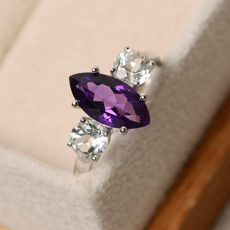 Silver Marquise Three-stone Ring, Elegant Purple Amethyst Ring With Marquise Cut, Elegant Purple Marquise Cut Amethyst Ring, Silver Marquise Three-stone Jewelry, Elegant Three Stone Amethyst Promise Ring, Marquise Amethyst Ring In Purple, Marquise Amethyst Jewelry With Accent Stones, Elegant Amethyst Marquise Ring, Purple Marquise Amethyst Jewelry