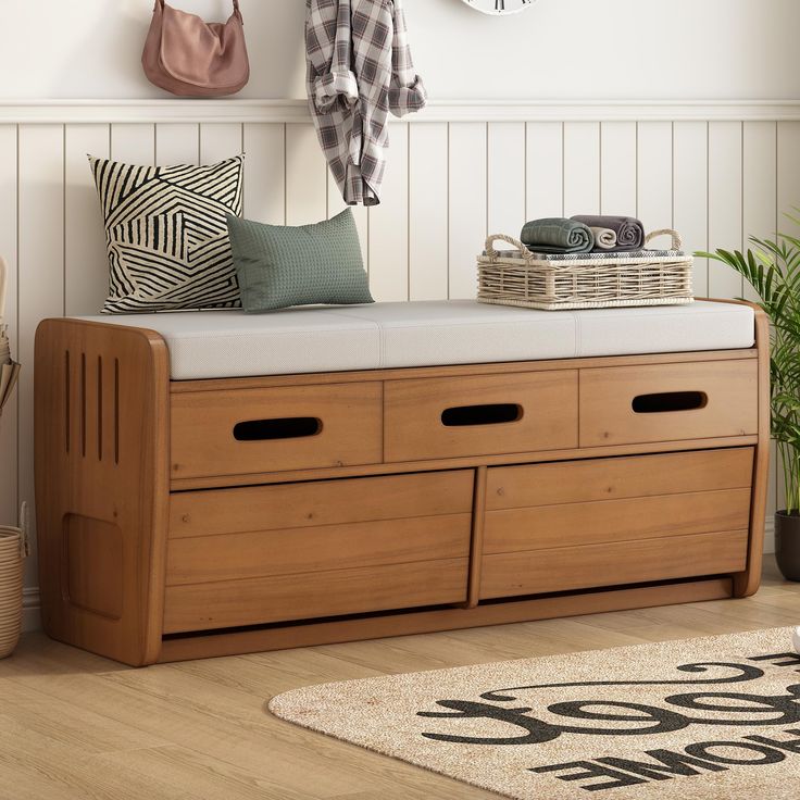 a wooden bench with two drawers underneath a coat rack and hanging hooks on the wall