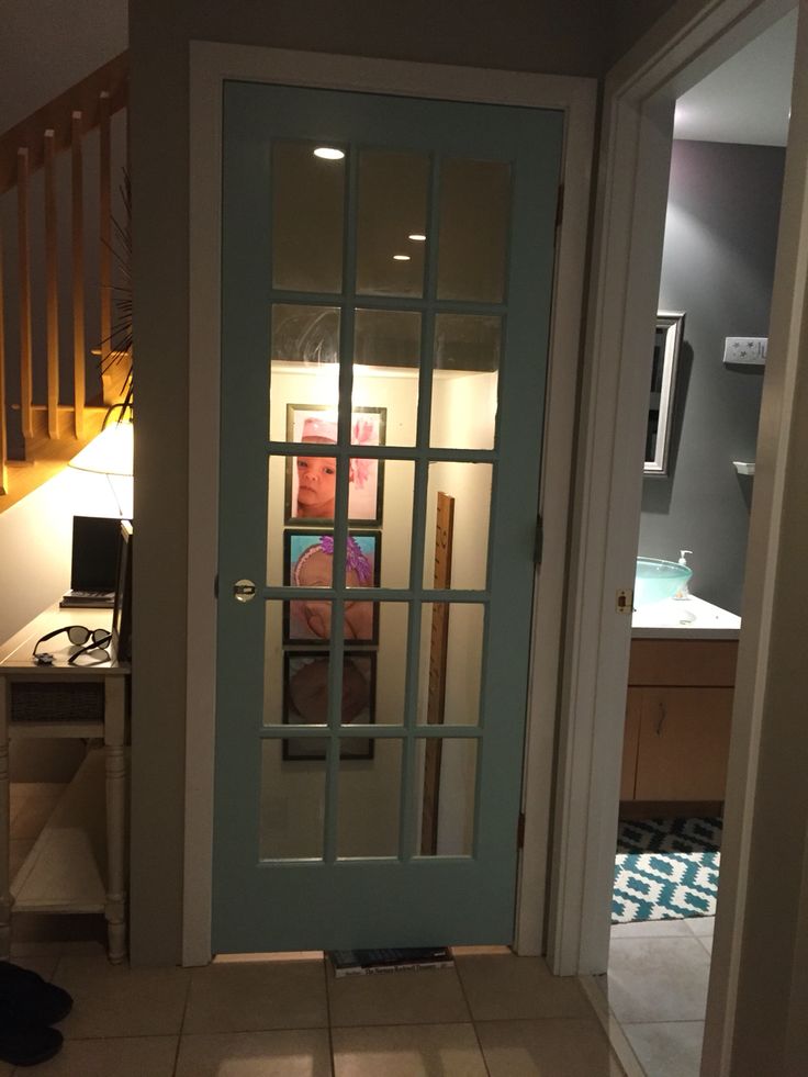 a man is reflected in the glass door of his home's entryway area