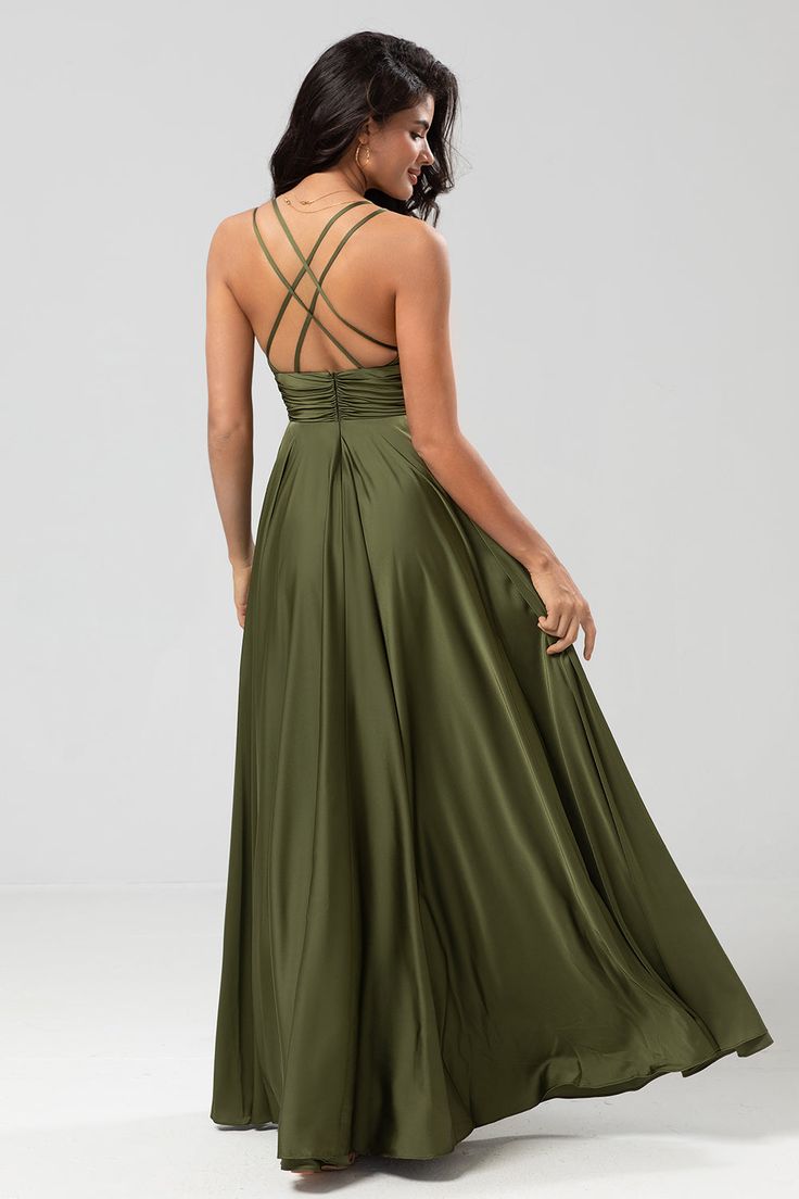 a woman in a long green dress is looking back at the camera with her hand on her hip