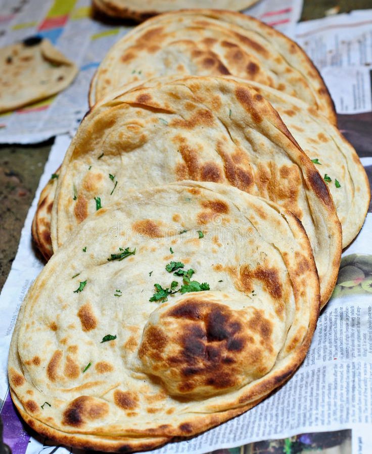 several flat breads are sitting on top of newspaper