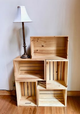 three wooden crates stacked on top of each other with a lamp in the corner next to them