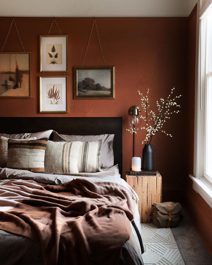 a bedroom with brown walls and pictures on the wall