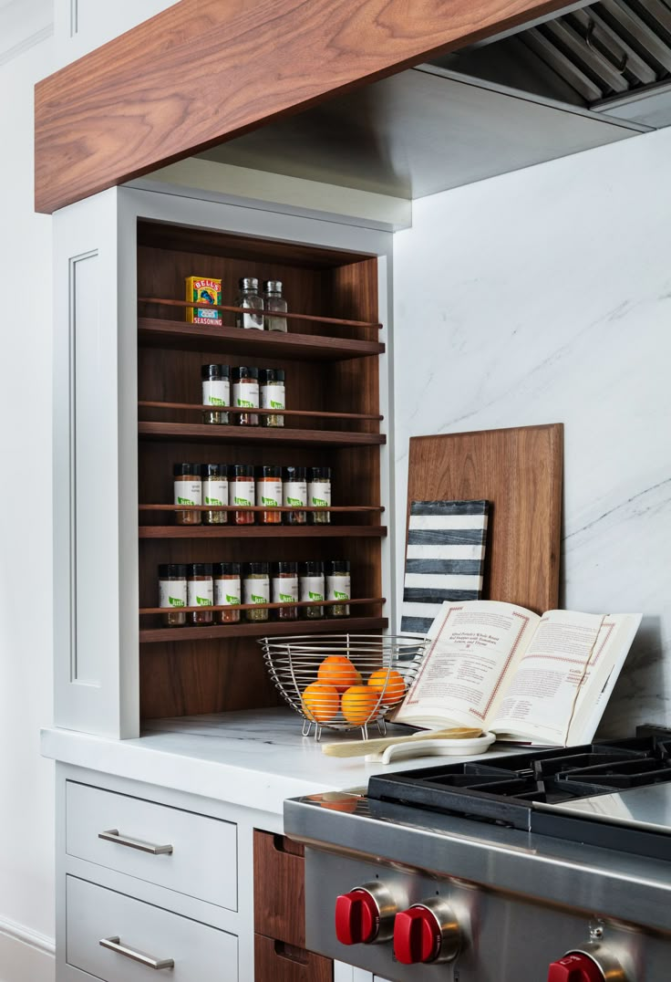 an open book is sitting on the counter next to some oranges and other items