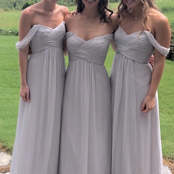 three bridesmaids in long gray dresses posing for the camera