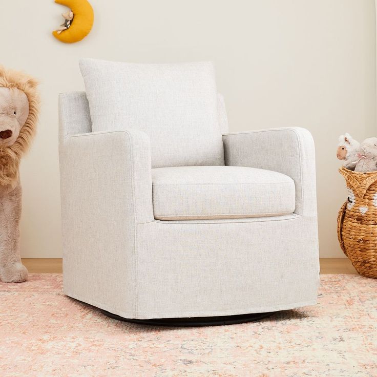 a white chair sitting on top of a rug next to a stuffed animal in a room