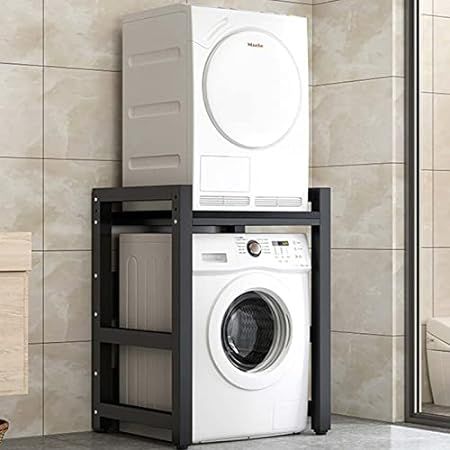 a washer and dryer stacked on top of each other in a room with tiled walls