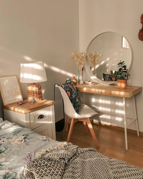 a bedroom with a bed, desk and mirror on the wall next to each other