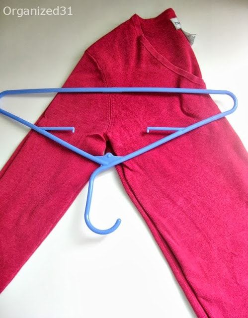 an unzipped pink sweat suit with blue string attached to the bottom and side