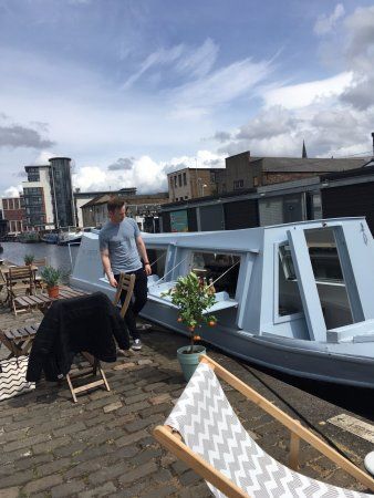 a man standing on top of a roof next to a small boat in the water