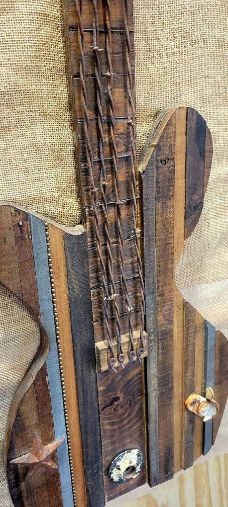 an old wooden guitar with strings attached to it