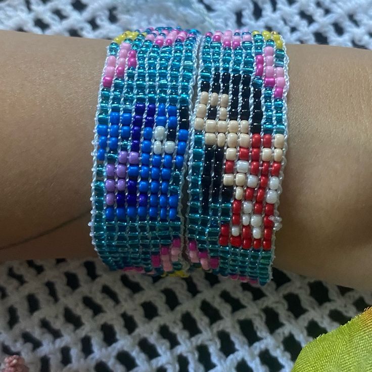 two colorful bracelets are on someone's arm