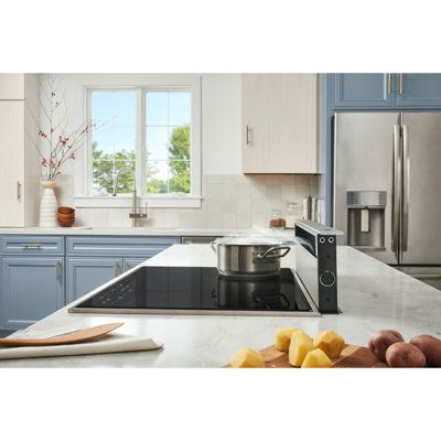 a kitchen with blue cabinets and white counter tops, stainless steel appliances and an island in the middle