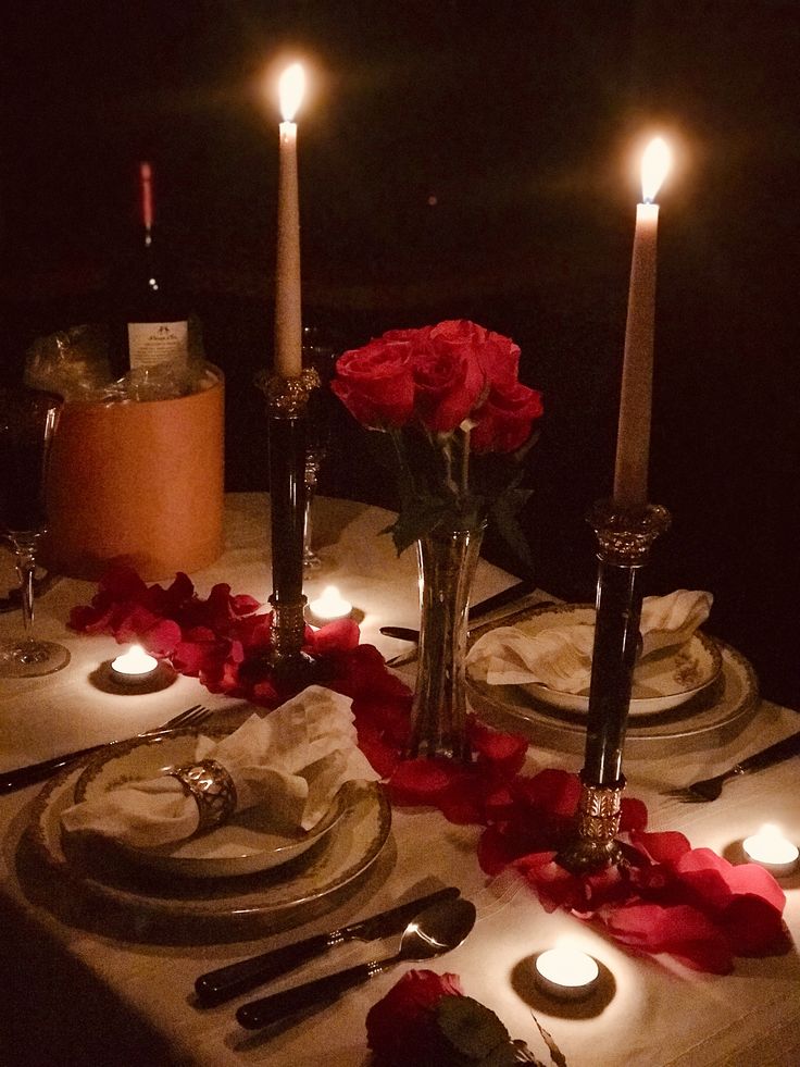 a table set with candles and flowers on it