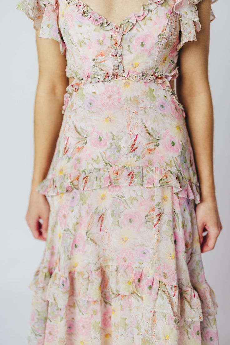 We think the gorgeous Millie Maxi Dress from ASTR is fit for a princess. It's all flowers and ruffles and utterly romantic, perfect for a special vacation dinner, or for when you want to RSVP "elegant" to a spring wedding or shower. This dress doesn't skimp on the feminine details, and deserves a place of honor in your closet! FIT: Runs true to size. Bust is fitted, with a low neckline and bodice cut-outs. MATERIAL: GARMENT DETAILS: Floral chiffon maxi dress, with a plunging V-neckline, multi-ti Elegant Dress With Ruffled Skirt For Garden Party, Chic Floral Print Ruffle Dress For Garden Party, Floral Print Ruffle Dress For Garden Party, Ruffled Dresses For Vacation Garden Party, Feminine Floral Print Ruffle Dress With Ruffled Straps, Feminine Floral Print Mini Dress For Garden Party, Feminine Midi Dress With Ruffle Hem For Garden Party, Elegant Mini Dress With Ruffled Skirt For Garden Party, Elegant Ruffled Mini Dress For Garden Party