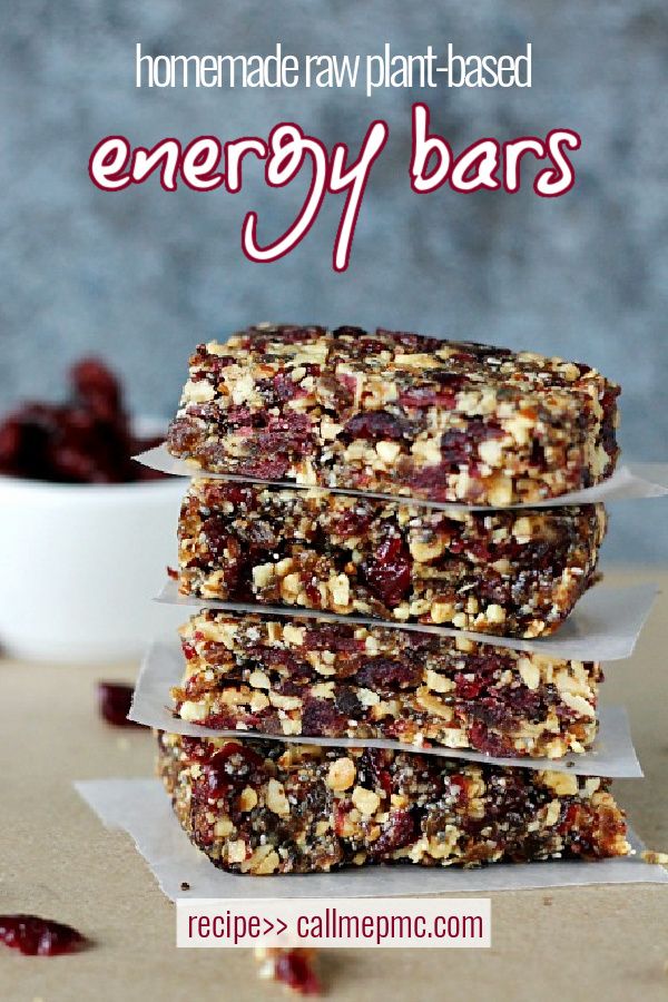 three granola bars stacked on top of each other with cranberries in the background