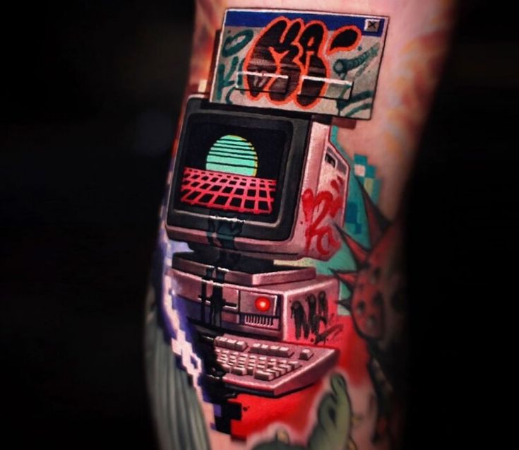 a man's arm with an old school computer tattoo on it, and the image is