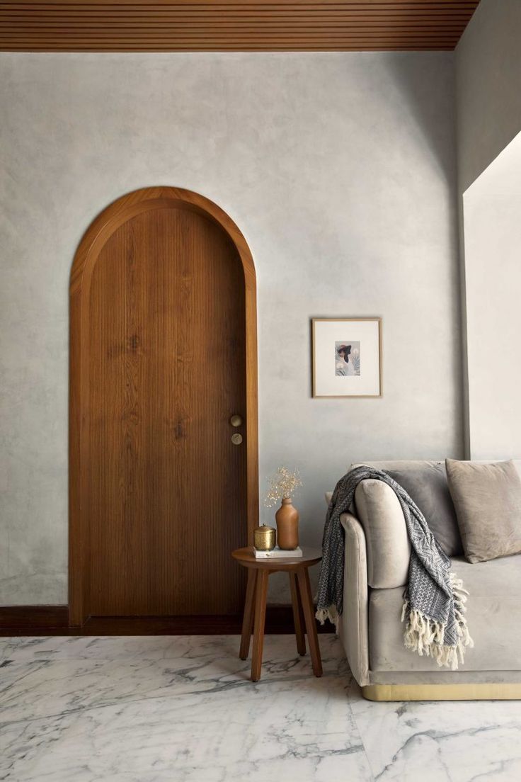 a living room with a couch, table and wooden door in it's center