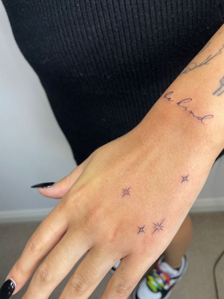 a woman's hand with stars on it and the word love written in cursive writing