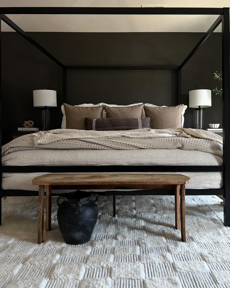 a bedroom with a four poster bed and two lamps on either side of the bed