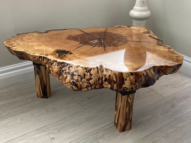 a table made out of wood with a flower design on the top and two legs