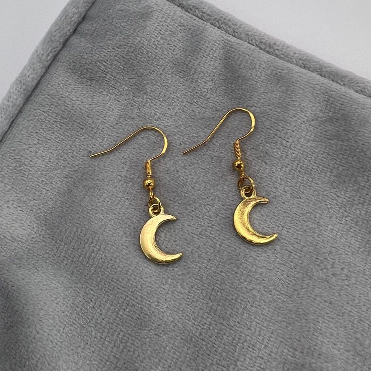 Handmade Gold Moon Dangle Hook Earrings - Cute Hypoallergenic Statement Earrings These earrings are handmade in the UK, all findings and finishings are 925 Sterling or Gold plated 925 Sterling Silver (nickel and lead free) making them all hypoallergenic, perfect for sensitive ears. Each pair is designed and created with care and is backed on one of our Furnessities signature cards and wrapped in tissue paper to ensure safety whilst in transit.  *Designs and colours may vary slightly as each earring pair is handmade and unique* Care instructions: All items are handmade so take care removing from the card and your ears. Not recommended for wear in water. Keep out of the reach of small children as they could be a choking hazard.  Returns: We are unable to accept returns or exchanges of earrin Minimalist Moon Charm Drop Earrings, Gold Single Moon-shaped Earring, Dainty Half Moon Charm Earrings, Dainty Half Moon Earrings With Moon Charm, Dainty Moon Shaped Single Earring, Dainty Single Moon Earring, Gold Moon Shaped Pierced Earrings, Gold Moon-shaped Pierced Earrings, Gold Moon-shaped Earrings With Moon Charm