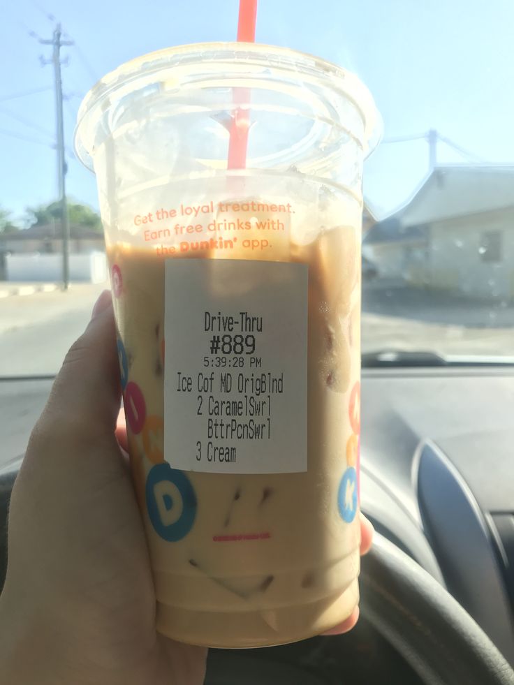 a person holding up a drink in their hand with the label on it that says drive thru