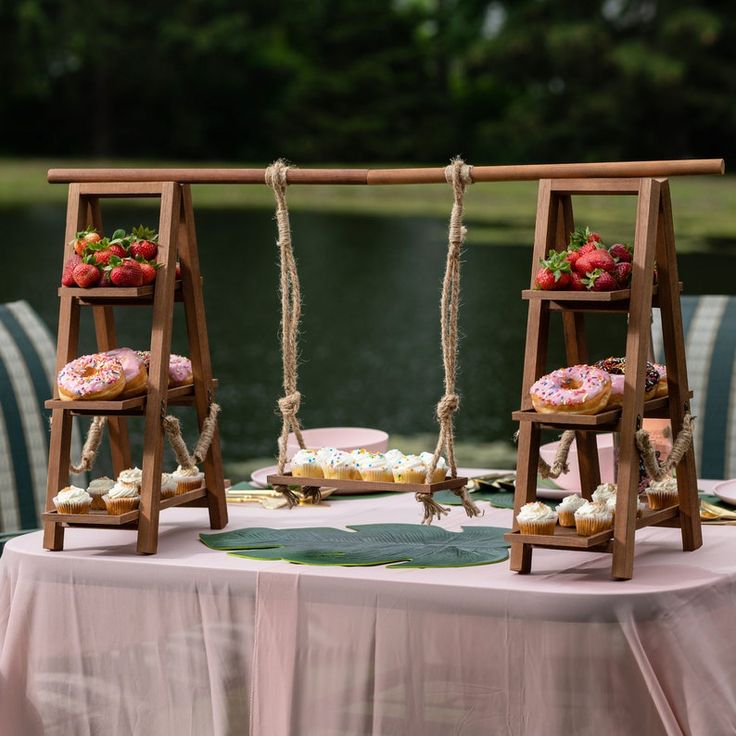 two wooden swings with donuts on them are set up for an outdoor wedding reception