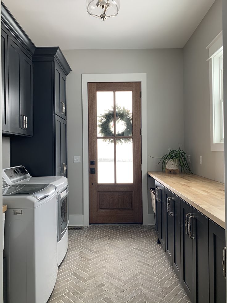 a washer and dryer are in front of a door with a wreath on it