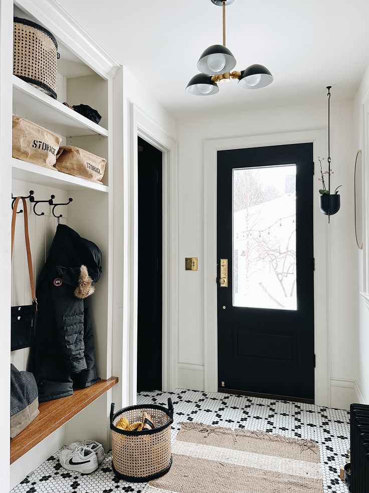 a black and white tiled entryway with a basket on the floor next to it