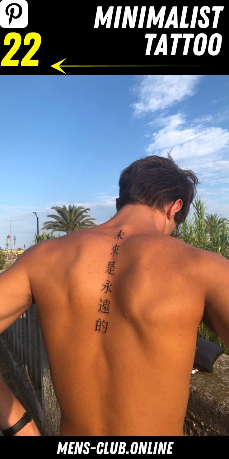 the back of a man with chinese writing on his upper and lower back, standing in front of a fence