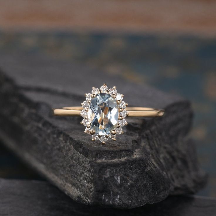 an engagement ring with a blue topazte surrounded by white diamonds on a rock