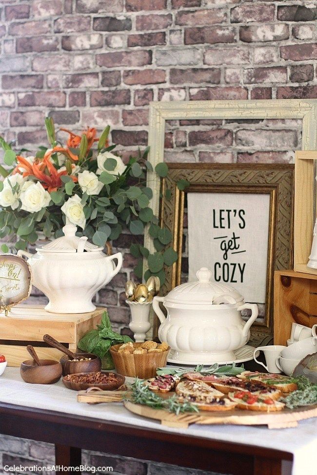 a table topped with lots of food next to a brick wall