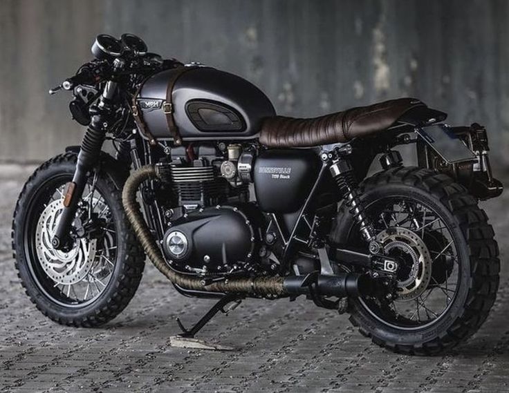 a black motorcycle parked in front of a wall