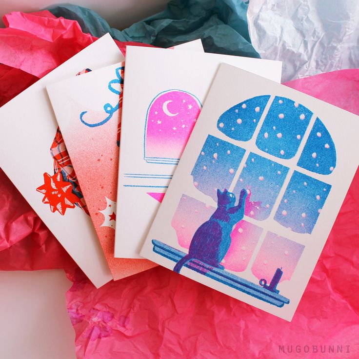 three greeting cards on top of pink tissue paper with an image of a cat looking out the window