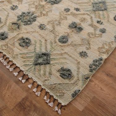 a beige and blue area rug on top of a wooden floor