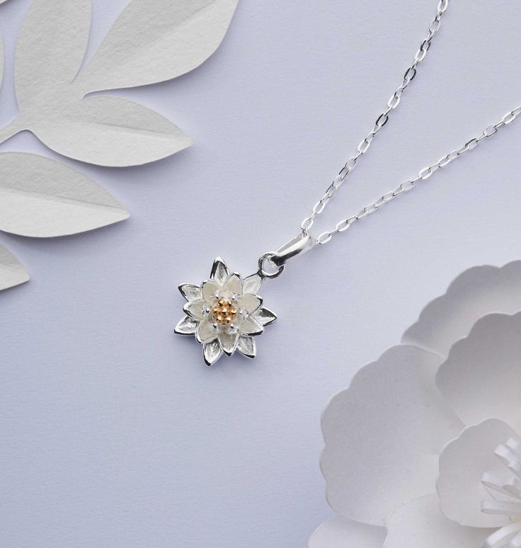 A magical tiny silver water lily necklace. Inspired by nature, this beautiful little solid 925 sterling silver three-dimensional flower pendant with an 18ct  gold plated centre comes in a choice of chain lengths. The Water lily is the birth flower for July and it symbolises innocence, purity and peace. FEATURES: ✥  Comes beautifully packaged and gift-ready.  ✥  Made from solid 925 sterling silver.  ✥  Ideal if you have allergies to base metals. ✥  Only the finest precious metals used. ✥  Comes w Lily Necklace Flower, Lily Flower Necklace, Water Lily Necklace, Spiritual White Flower Necklaces, White Flower Necklace With Nature-inspired Style, Elegant White Flower Necklace With Birth Flower Detail, Nature-inspired White Birth Flower Necklace, White Flower-shaped Nature-inspired Necklace, Elegant White Flower Necklace For Birth Month