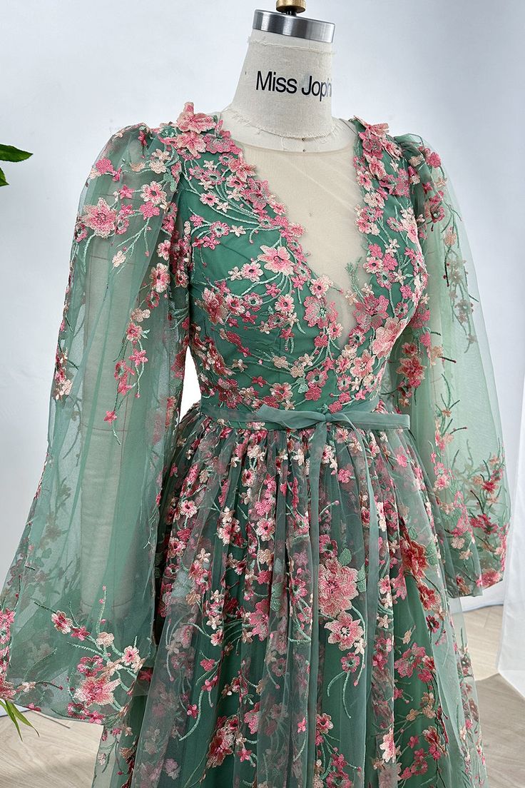 Indulge in the elegance of our Long Sleeves O Neck Pink Floral Embroidery Sage Tulle Dress. Adorned with intricate floral embroidery and crafted from delicate tulle, this dress exudes sophistication and charm. The long sleeves provide coverage while the O neck adds a touch of femininity. Perfect for special occasions and making a statement. Bust and Skirt with full lining. 100% Polyester 100% Recycled polyester lining Concealed zip at center back Imported Green Floral Embroidered Evening Gown, Evening Gown With Floral Embroidery In Green, Elegant Green Gown With Floral Embroidery, Elegant Organza Dress With 3d Embroidery, Fitted Green Gown With Floral Applique, Elegant Green Dress With Floral Embroidery, Long Sleeve Embroidered Gown For Spring, Spring Formal Gown With Intricate Embroidery, Floor-length Dress With Multicolor Floral Embroidery