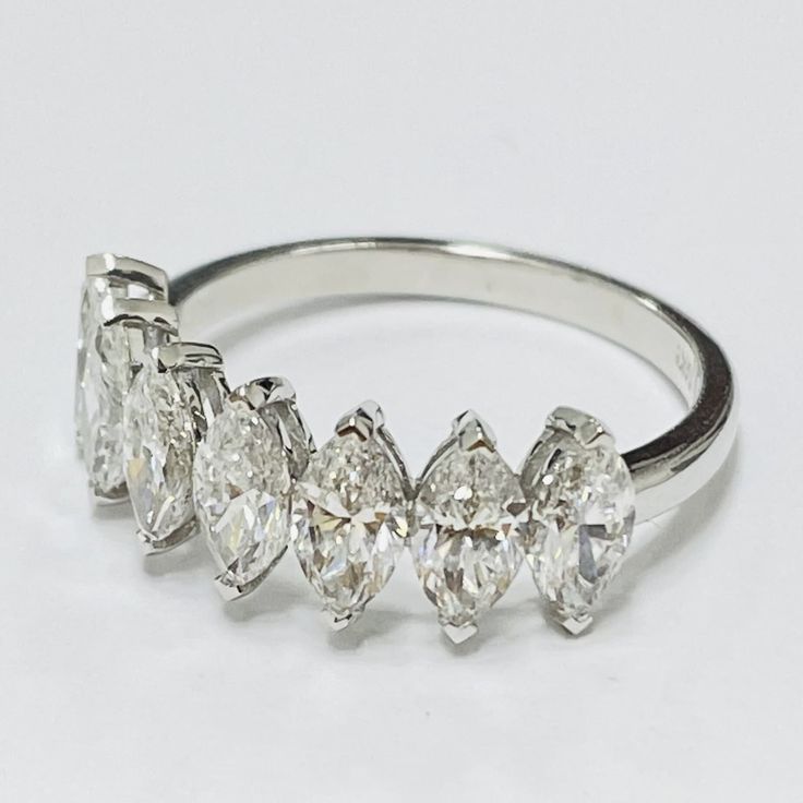 three pear shaped diamond rings on a white background, set in 18k white gold