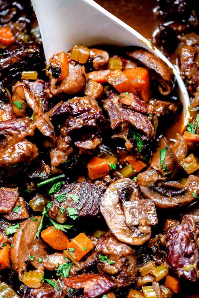 cooked meat and vegetables in a skillet with a spatula on the side, ready to be eaten