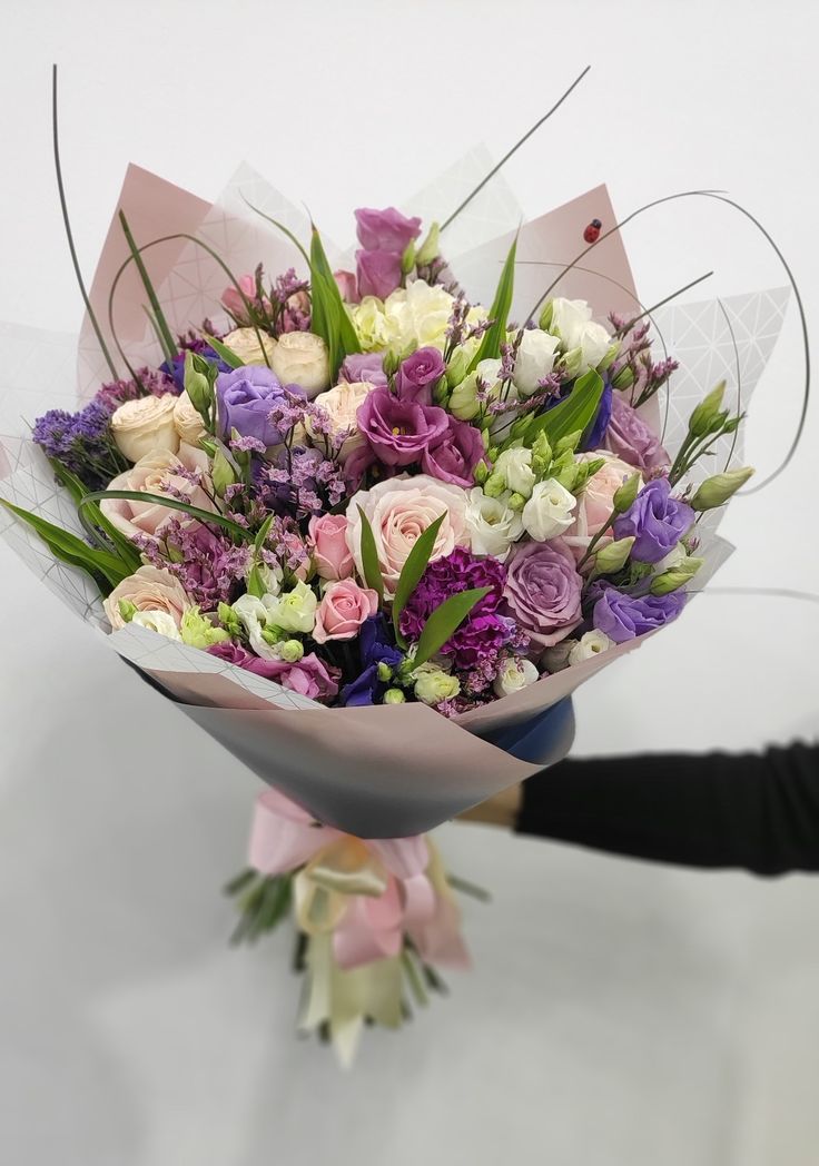 a woman holding a bouquet of flowers in her hand