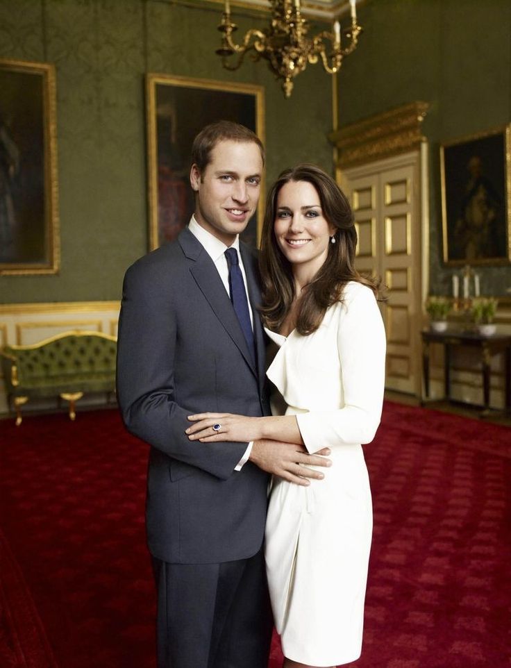 a man and woman in formal attire posing for a photo on the red carpeted room