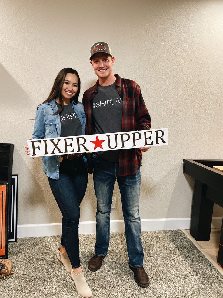 a man and woman standing next to each other holding a sign that says fixer upper