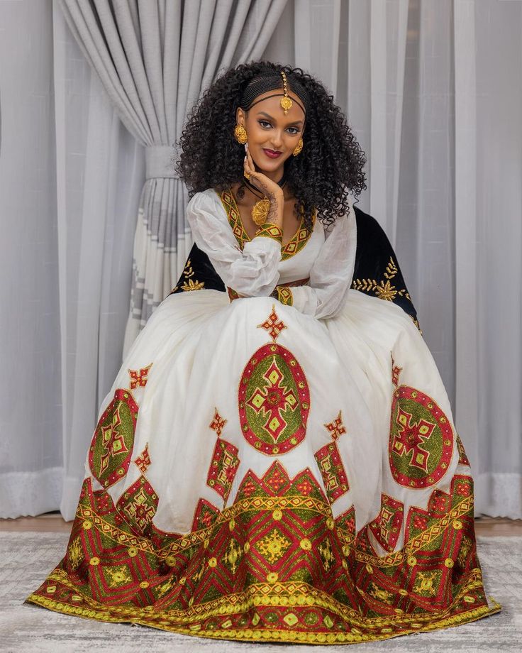 Description Adorn yourself in the mesmerizing beauty of Ethiopian tradition with our Beaded Detailed Habesha Kemis. This stunning ensemble features intricate patterns meticulously crafted with exquisite beads, showcasing the artistry and skill of Ethiopian artisans. Each bead is carefully placed to create a dazzling display of elegance and sophistication, adding a touch of opulence to the timeless silhouette of the Habesha dress. Whether worn for cultural ceremonies, weddings, or special events, our Habesha Kemis is a true masterpiece that pays homage to the rich heritage of Ethiopian dress while exuding contemporary allure. Step into the spotlight and embody the essence of Ethiopian beauty with this captivating ensemble. Material Menen Cotton Thread Estimated delivery : 5 weeks to 7 weeks Habesha Kemis Ethiopian Dress, Eritrean Flag, Ethiopian Wedding, Habesha Dress, Ethiopian Dress, Habesha Kemis, Mesmerizing Beauty, Religious Books, Beaded Wedding