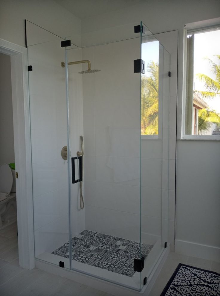 a bathroom with a walk in shower next to a toilet