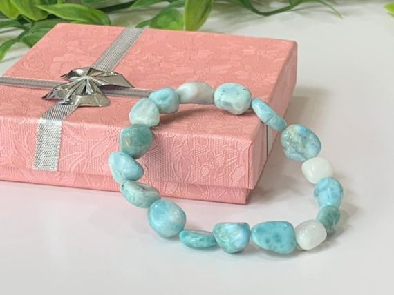 "Discounts: Buy 2 or more items, receive 20% Off. Buy 4 or more Items, receive 25% Off - This beautiful larimar stretch bracelet is made with authentic, high-quality DOMINICAN REPUBLIC larimar tumbler stones ranging in size from Large 12mm - 14mm and threaded with high-quality stretch cord so it easily rolls over your hand and wrist.   Natural Dominican Larimar is beautifully imperfect with each stone having its own unique variations in colors. Note: Please be aware that due to the natural variations in gemstone color and patterns, the bracelet you receive may have slight differences from the one pictured, ensuring its unique character.  Please See ALL Item Photos & VIDEO and Read Full Item Description Before Purchasing.  PRODUCT DETAILS ➤ Gemstone:  Dominican Larimar ➤ Bead Size(s):   12- Larimar Bracelet Jewelry Gift, Turquoise Larimar Bracelets For Gifts, Turquoise Larimar Bracelets As A Gift, Turquoise Crystal Bracelet With Gemstone Beads For Gifts, Crystal Bracelet With Stones As A Gift, Larimar Round Beads Jewelry For Gifts, Larimar Beaded Jewelry For Gifts, Larimar Beaded Jewelry Gift, Larimar Bead Jewelry For Gifts