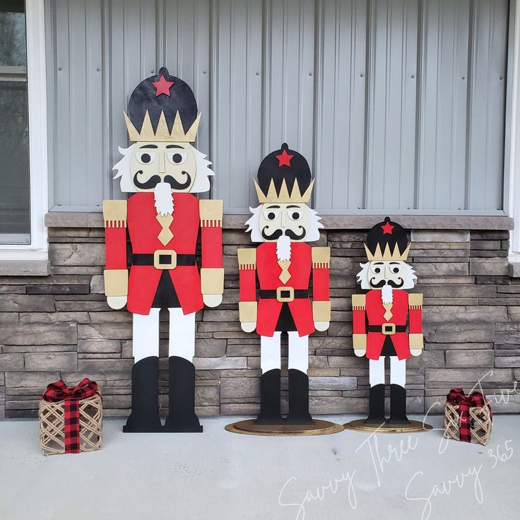 three wooden nutcrackers standing in front of a house